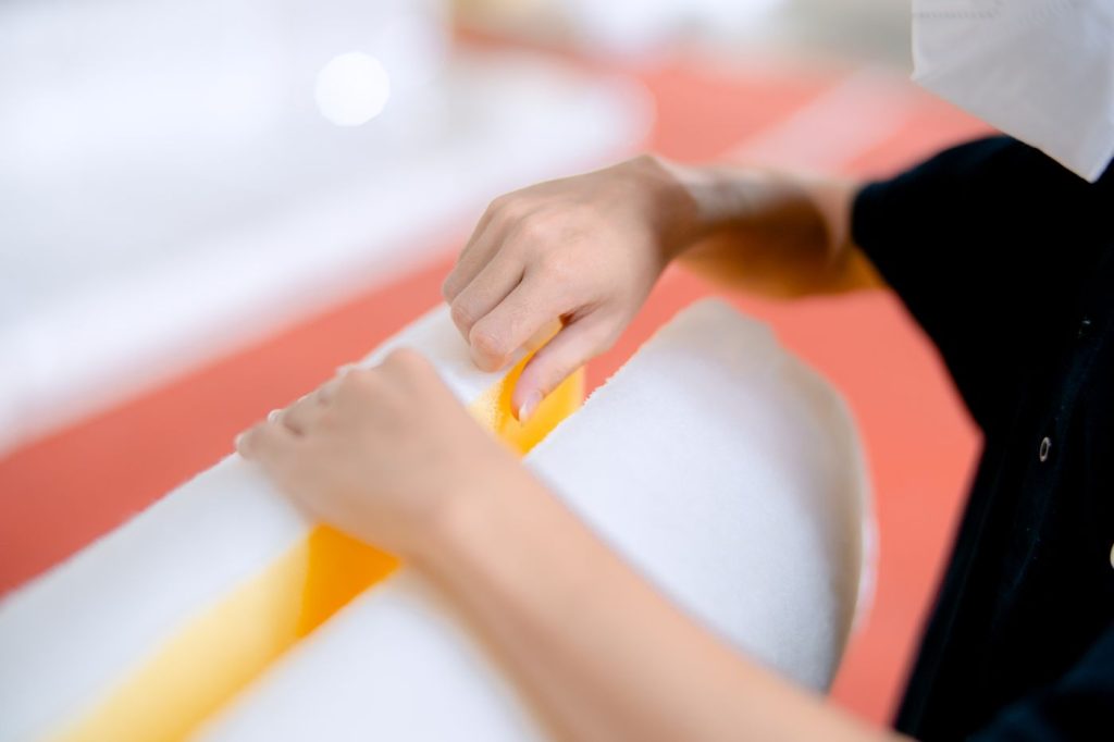Hands inspecting polyurethane foam cushioning material